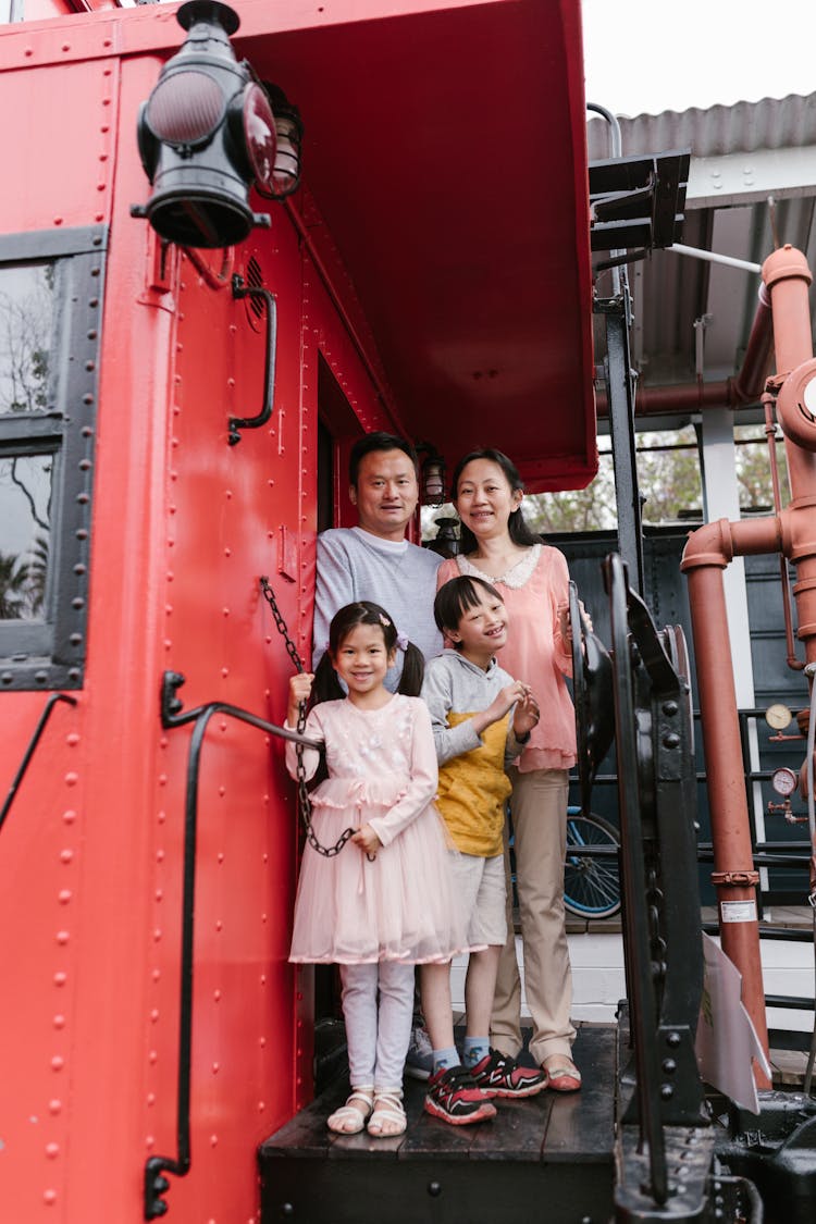 Parents With A Down Syndrome Son And Cute Daughter Standing On A Train