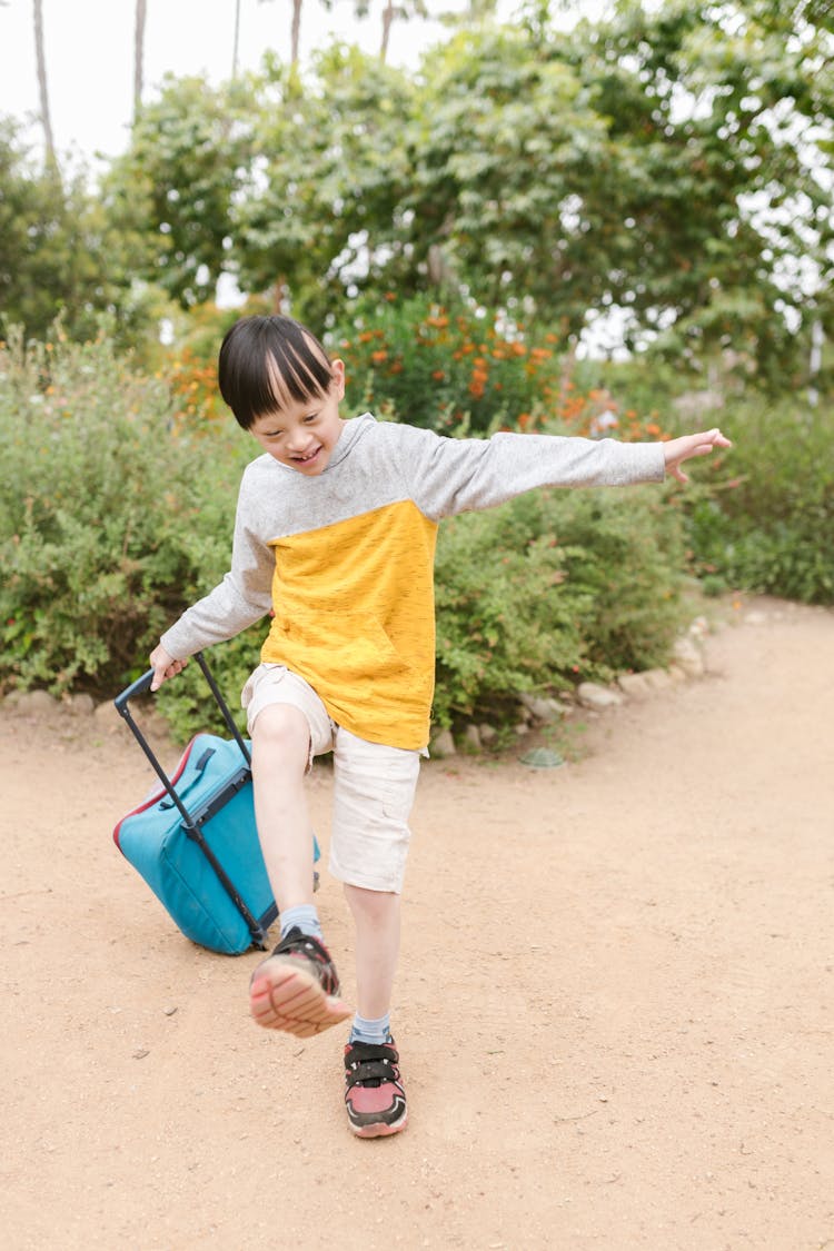 Happy Boy In Gray And Yellow Long Sleeve Shirt Holding A Blue Trolley Bag 