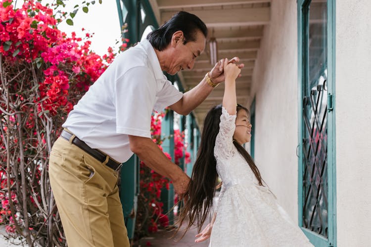 Grandfather And Granddaughter Dancing On The Alleyway