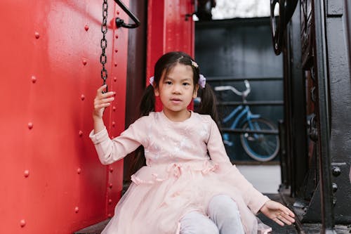 Woman in White Long Sleeve Dress Sitting on Swing