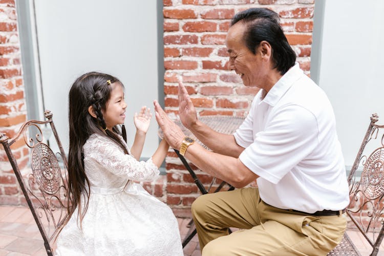 Photo Of A Kid Playing With Her Grandfather