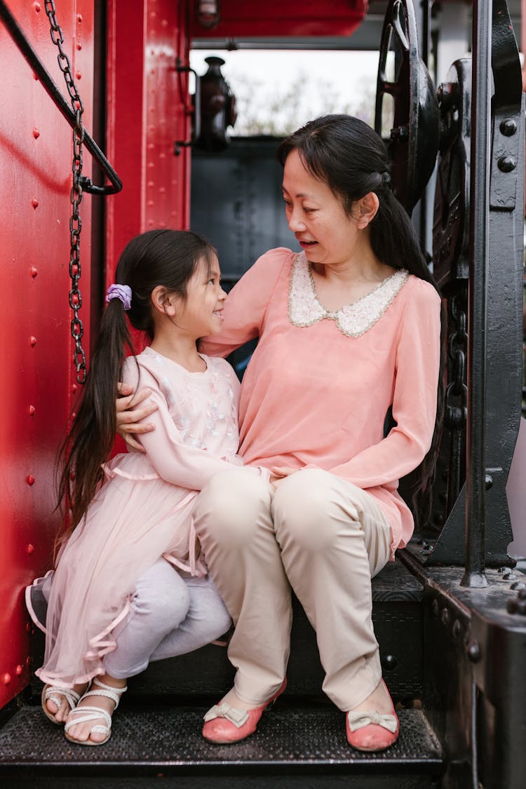 A Woman And Her Daughter Sitting Together