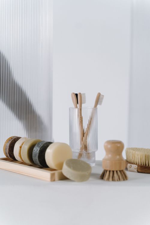 Free Stylish collection of eco-friendly bathroom essentials including wooden toothbrushes and natural soaps. Stock Photo