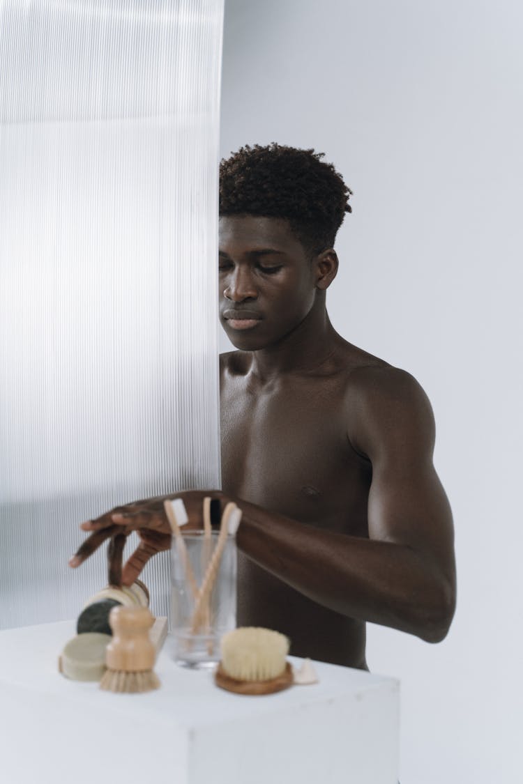 Shirtless Young Man Holding A Shower Brush