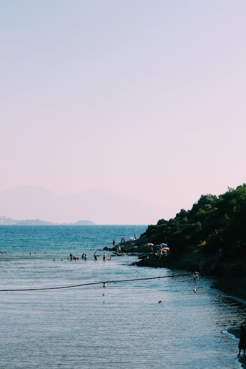 People Swimming on the Coast 