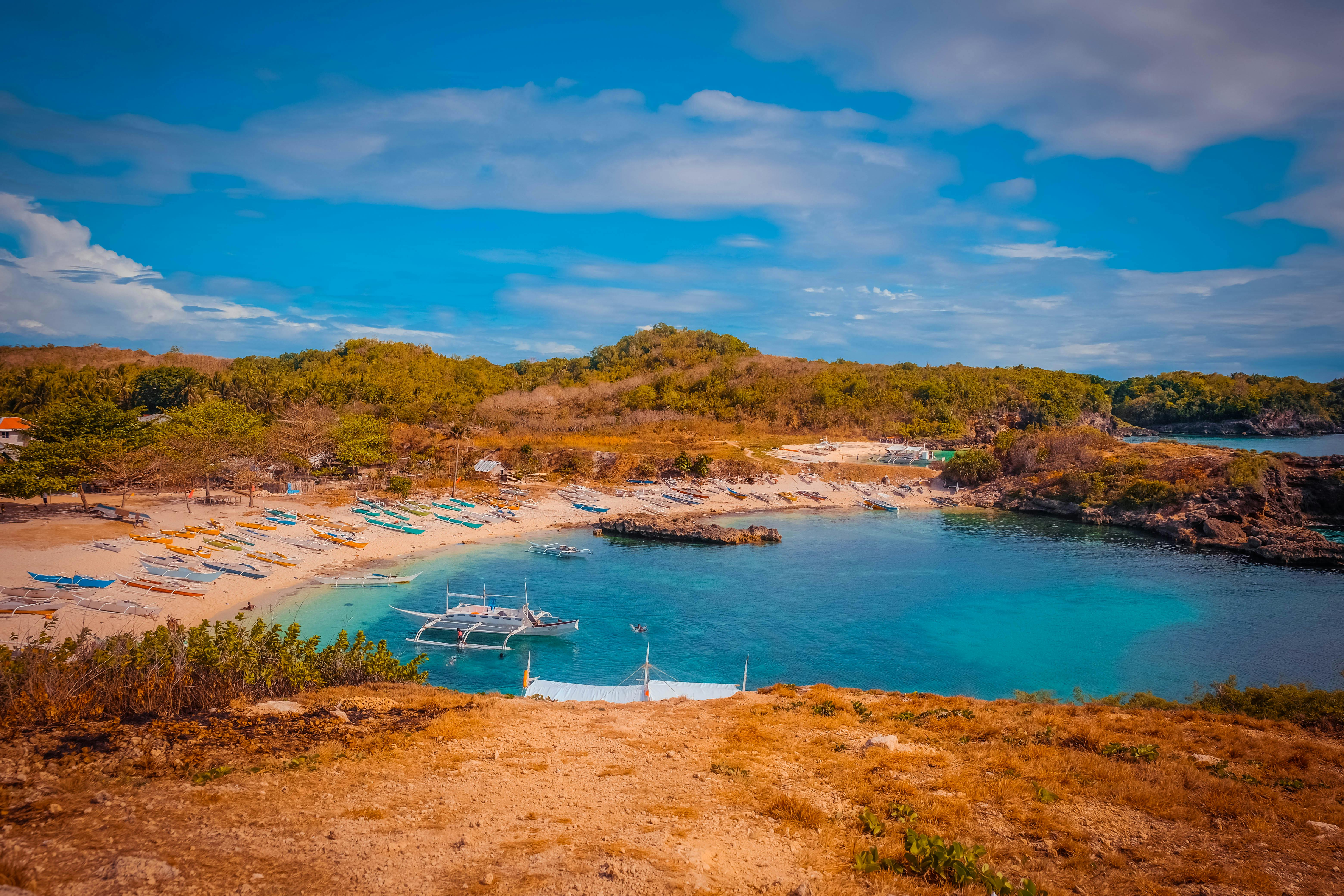 Beautiful beach cove with boats and blue water in the Philippines. (Photo: Juckelene Toledo)