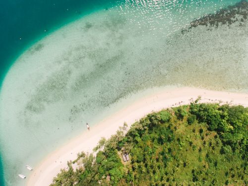 Free Stunning aerial view of a lush tropical island surrounded by clear turquoise waters. Stock Photo