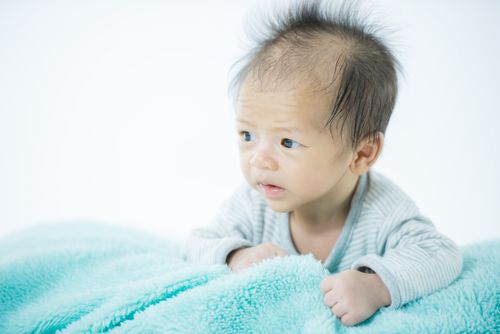 Free Charming baby portrait with a soft blue blanket, showcasing innocence and wonder. Stock Photo