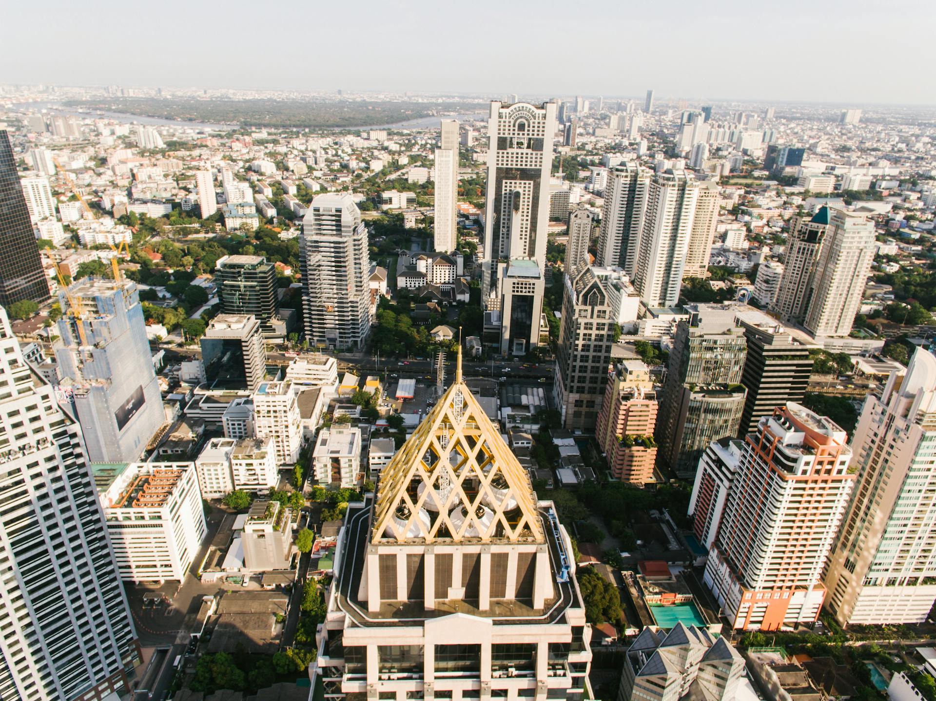 High-angle view of the bustling Bangkok cityscape under clear summer skies, showcasing modern architecture.