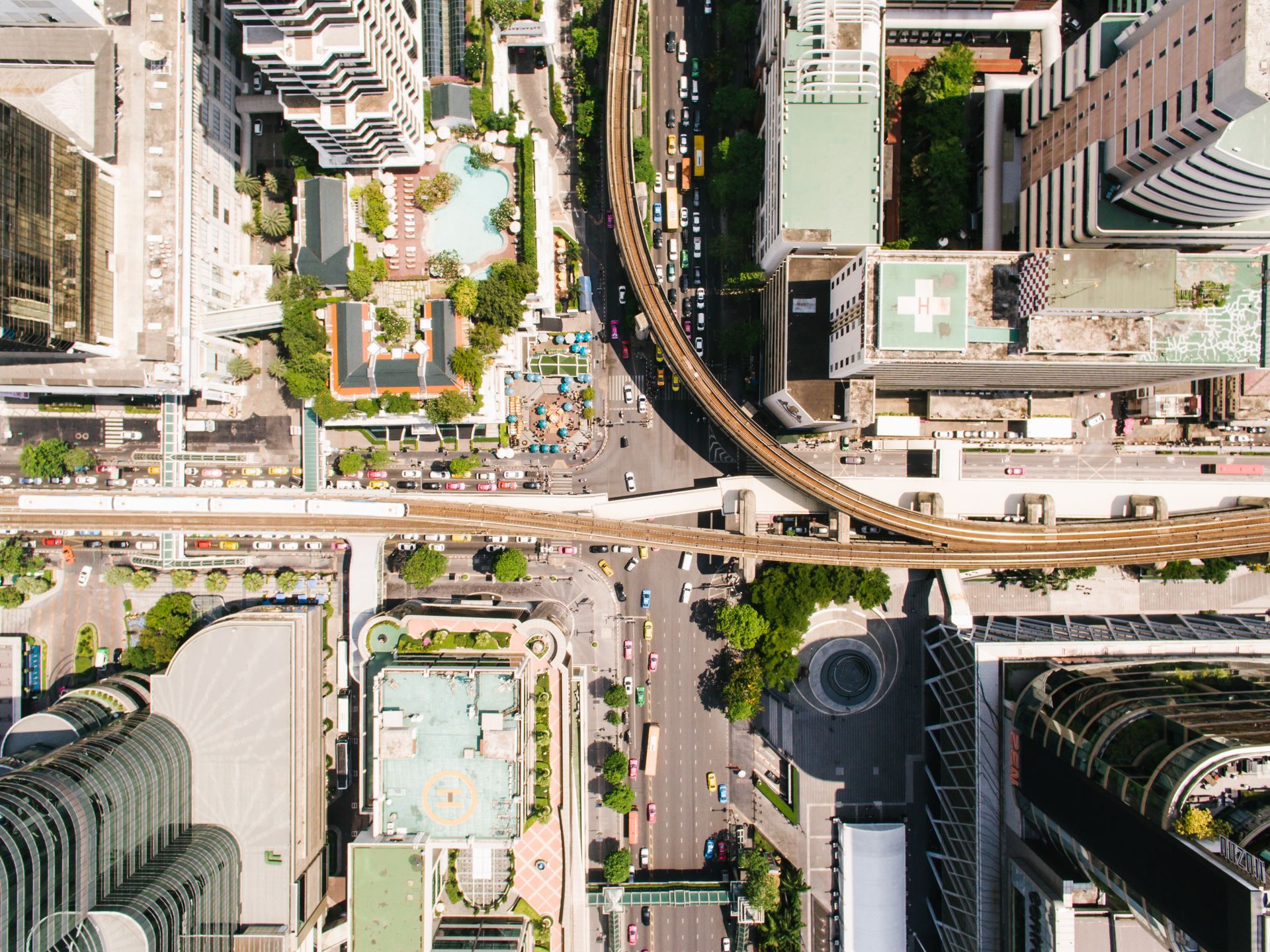 High-altitude drone shot of Bangkok's bustling cityscape showcasing urban infrastructure and vibrant streets.