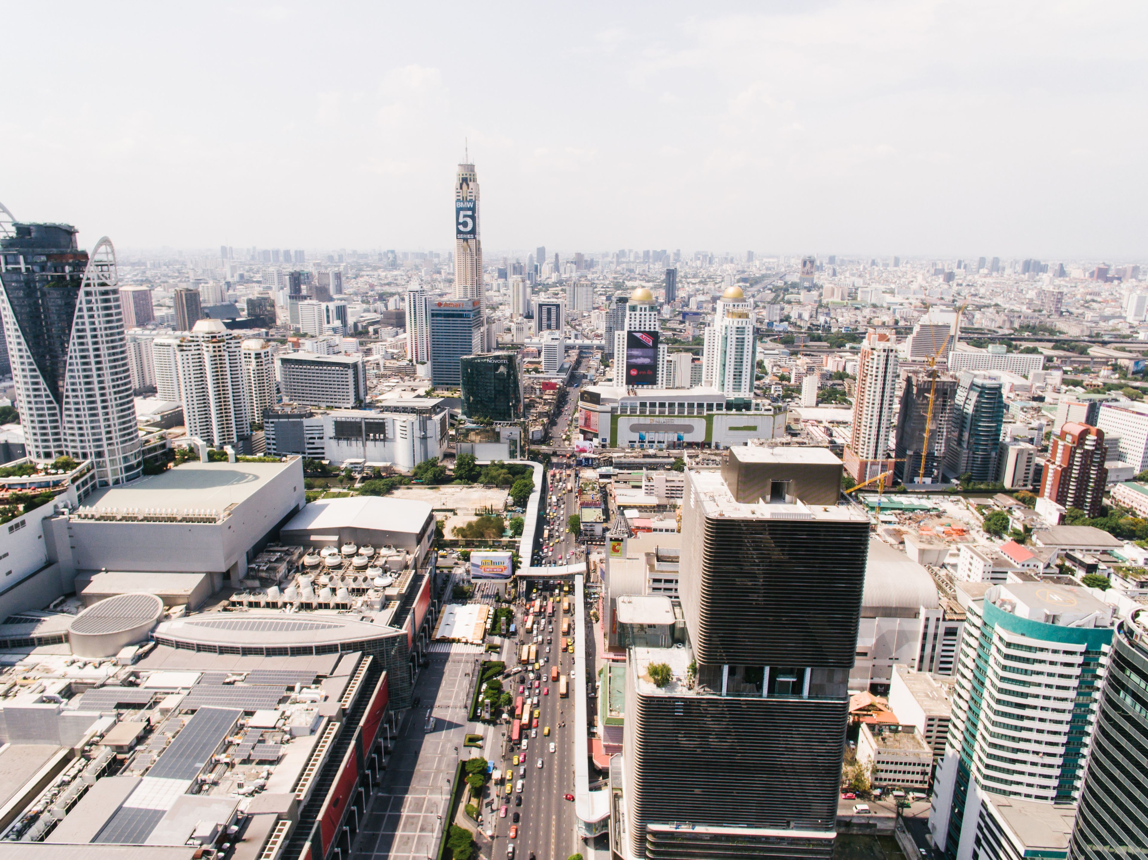 Stunning aerial view of Bangkok's bustling cityscape and skyscrapers on a sunny day.