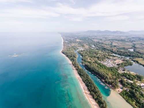 Free A breathtaking aerial view of a tropical coastline, lush greenery, and serene blue waters. Stock Photo