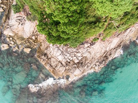 High-angle shot capturing the vibrant contrast of rocky cliffs and turquoise waters along the shore.