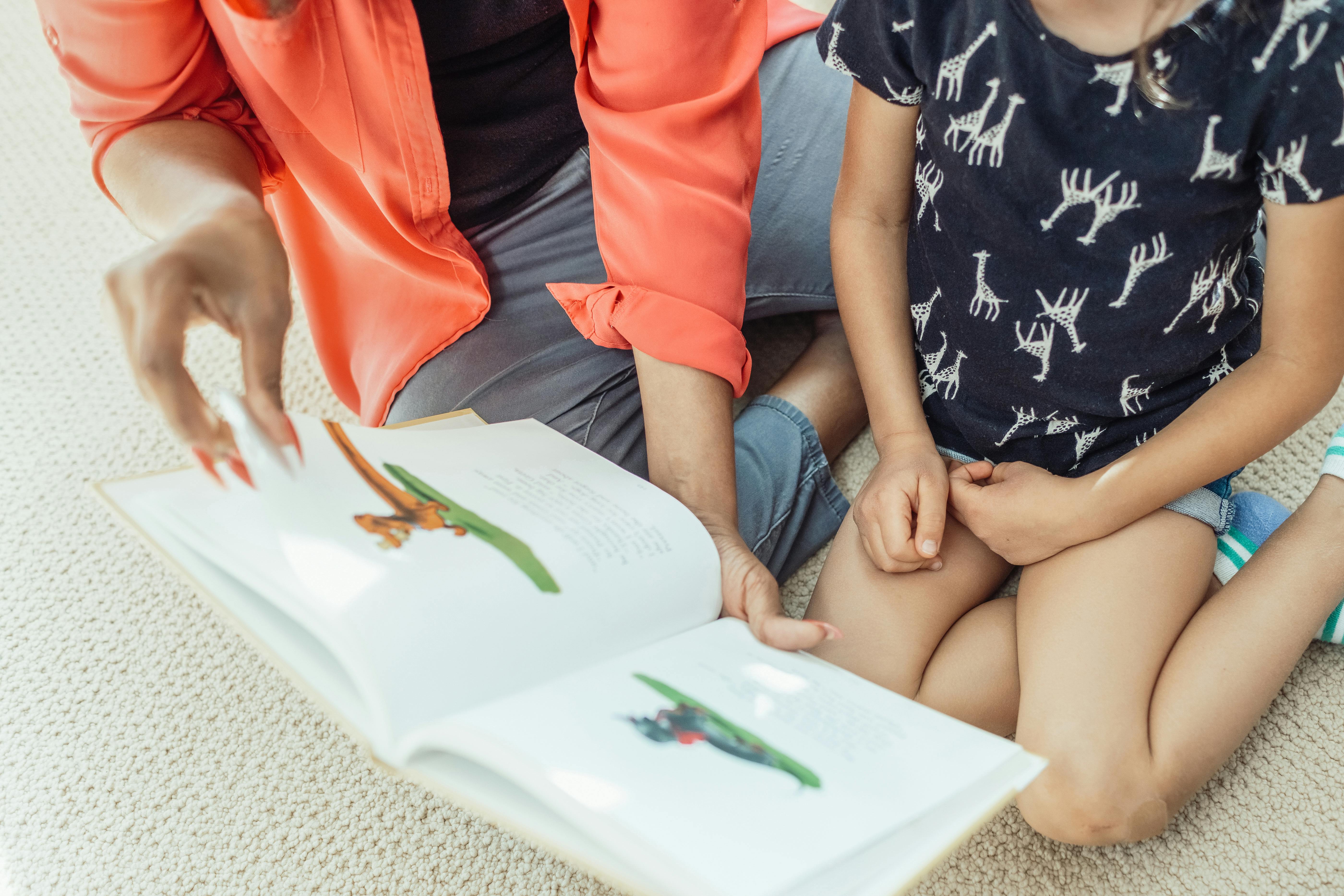 A Woman Reading a Children's Book to Her Daughter