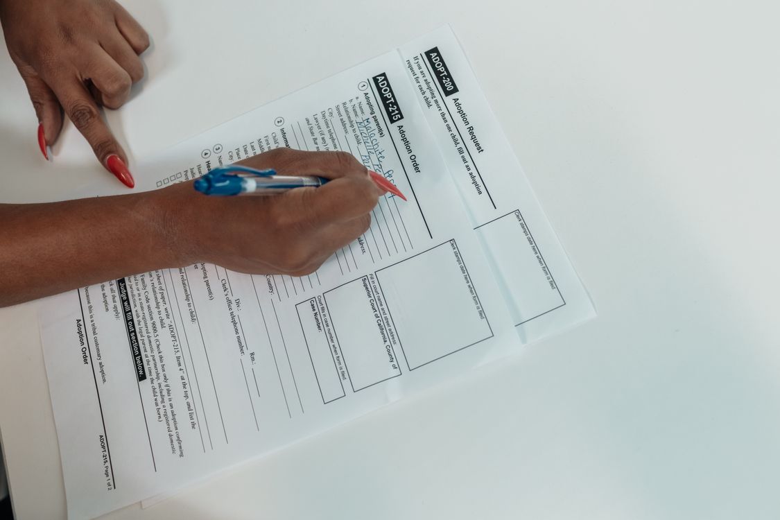 Person Writing on the Documents · Free Stock Photo