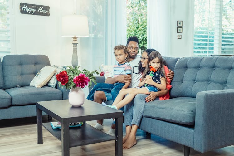 A Family Sitting On The Sofa Together 