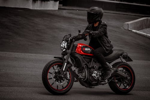 Person in Black Leather Jacket Riding a Motorcycle