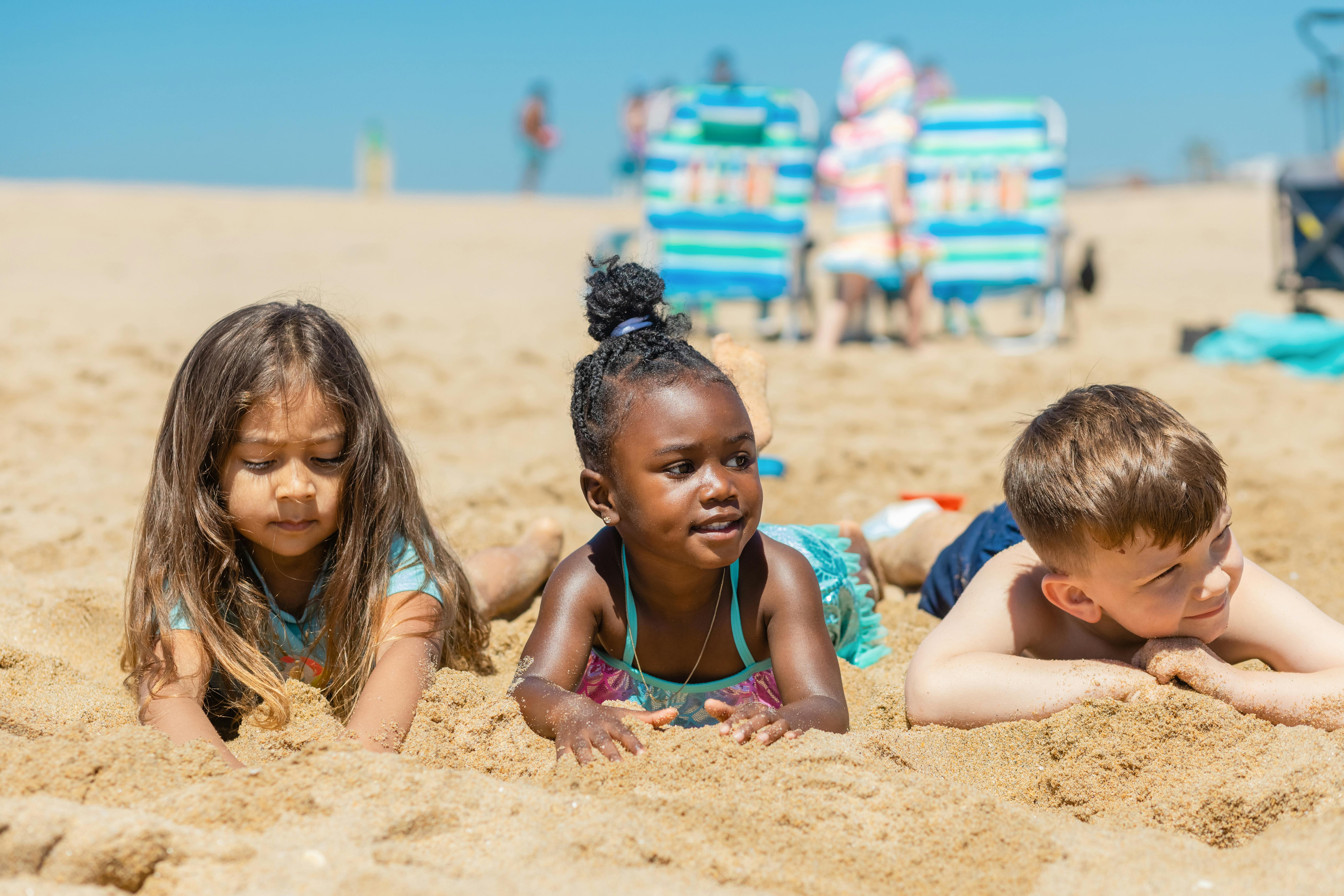 kids lying on sand