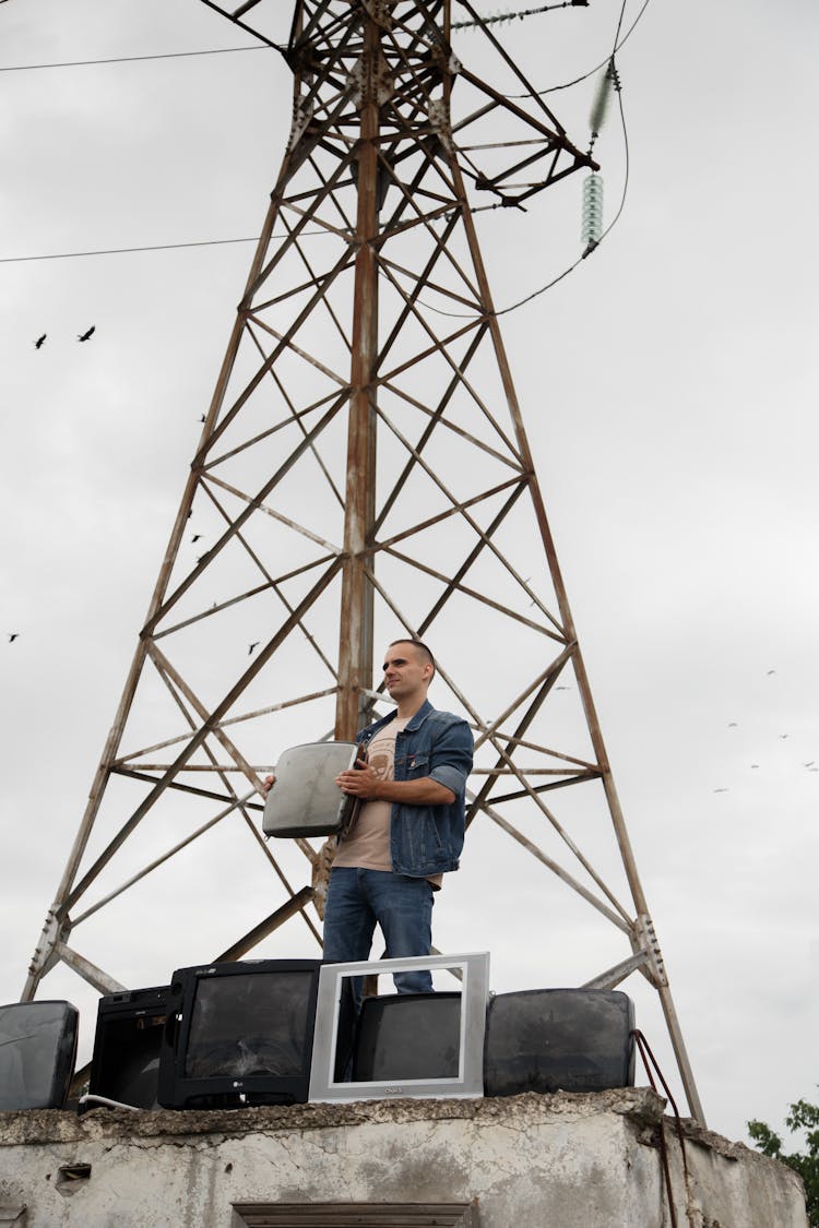 Man Standing By Electricity Pylon