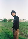 Man in Black Sweater Standing on Green Grass Field