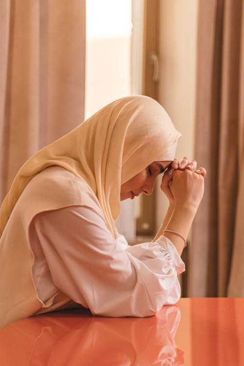 A Woman in Hijab Praying with Her Eyes Closed