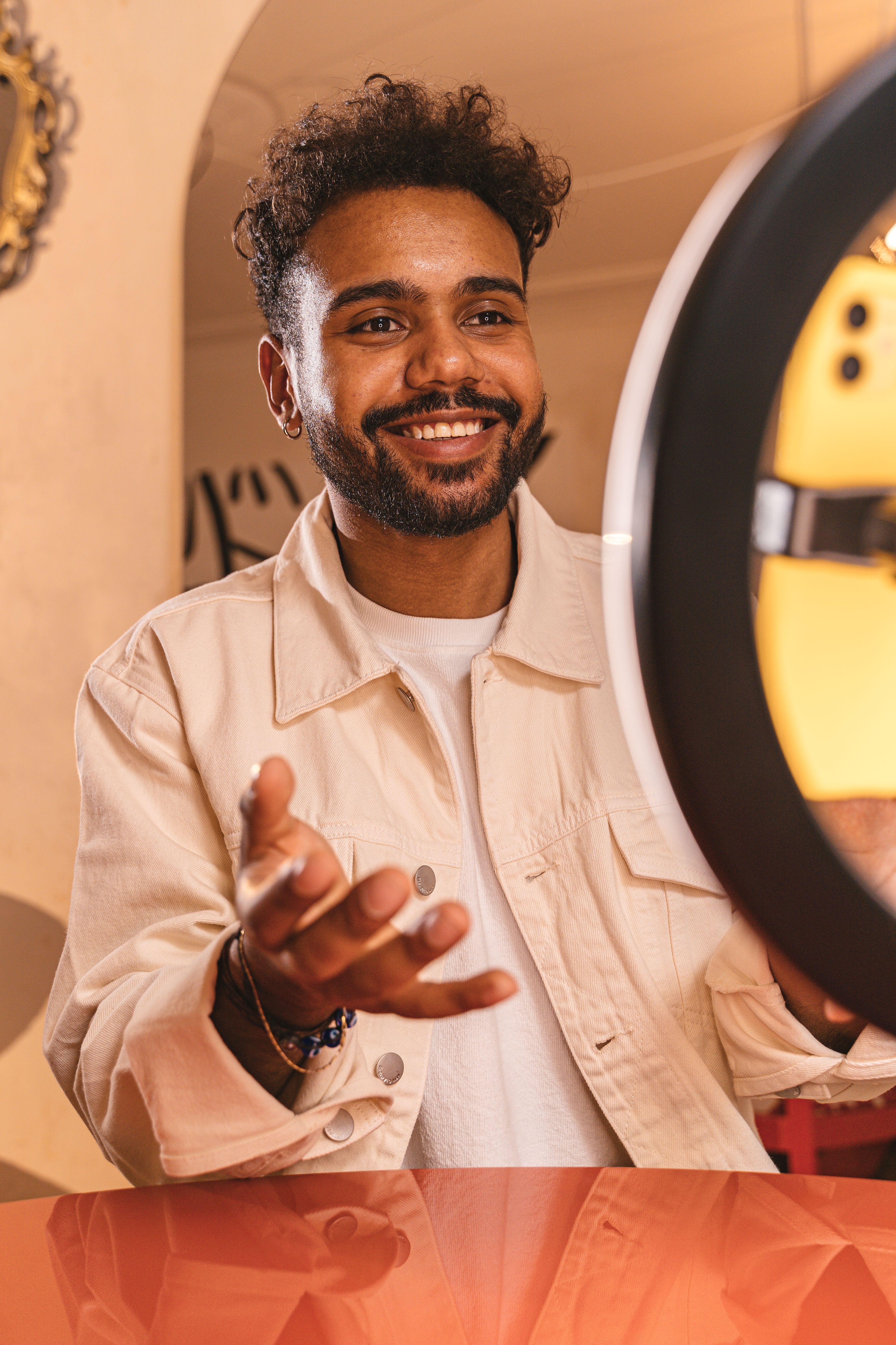 Happy man with beard posing indoors, illuminated by a ring light.
