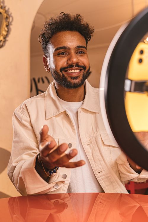 Free Happy man with beard posing indoors, illuminated by a ring light. Stock Photo