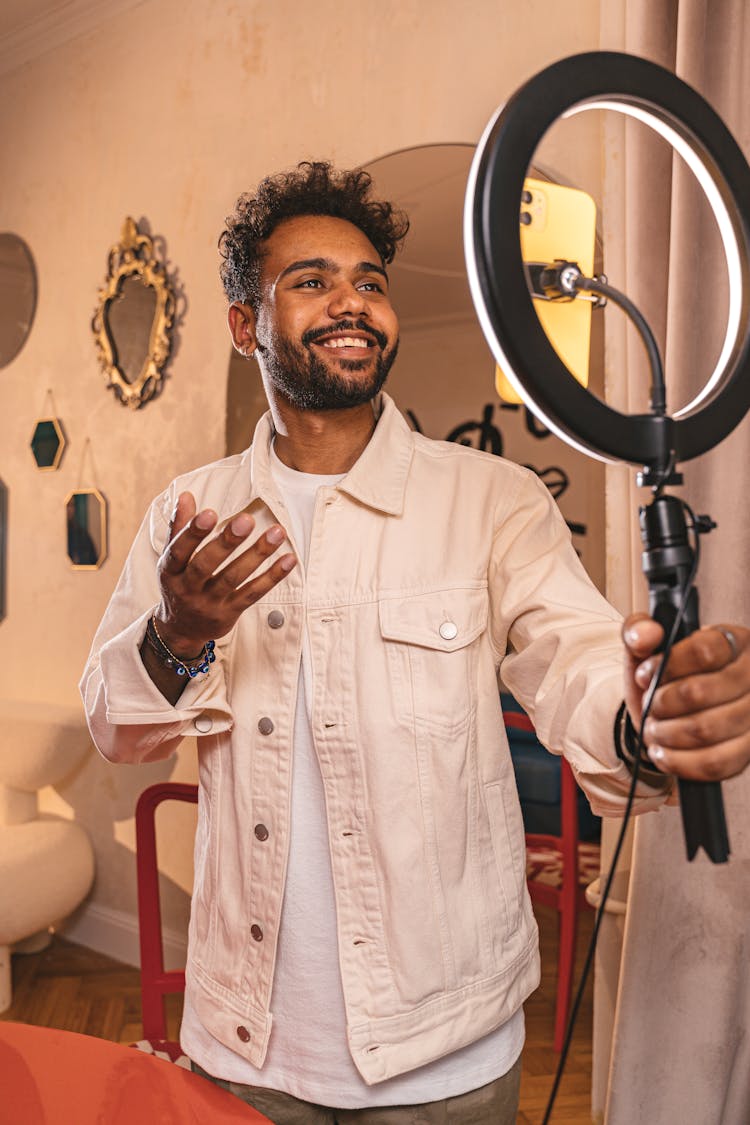 Smiling Man Filming On Smartphone With Ring Light