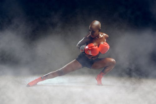 Black topless woman in boxing gloves