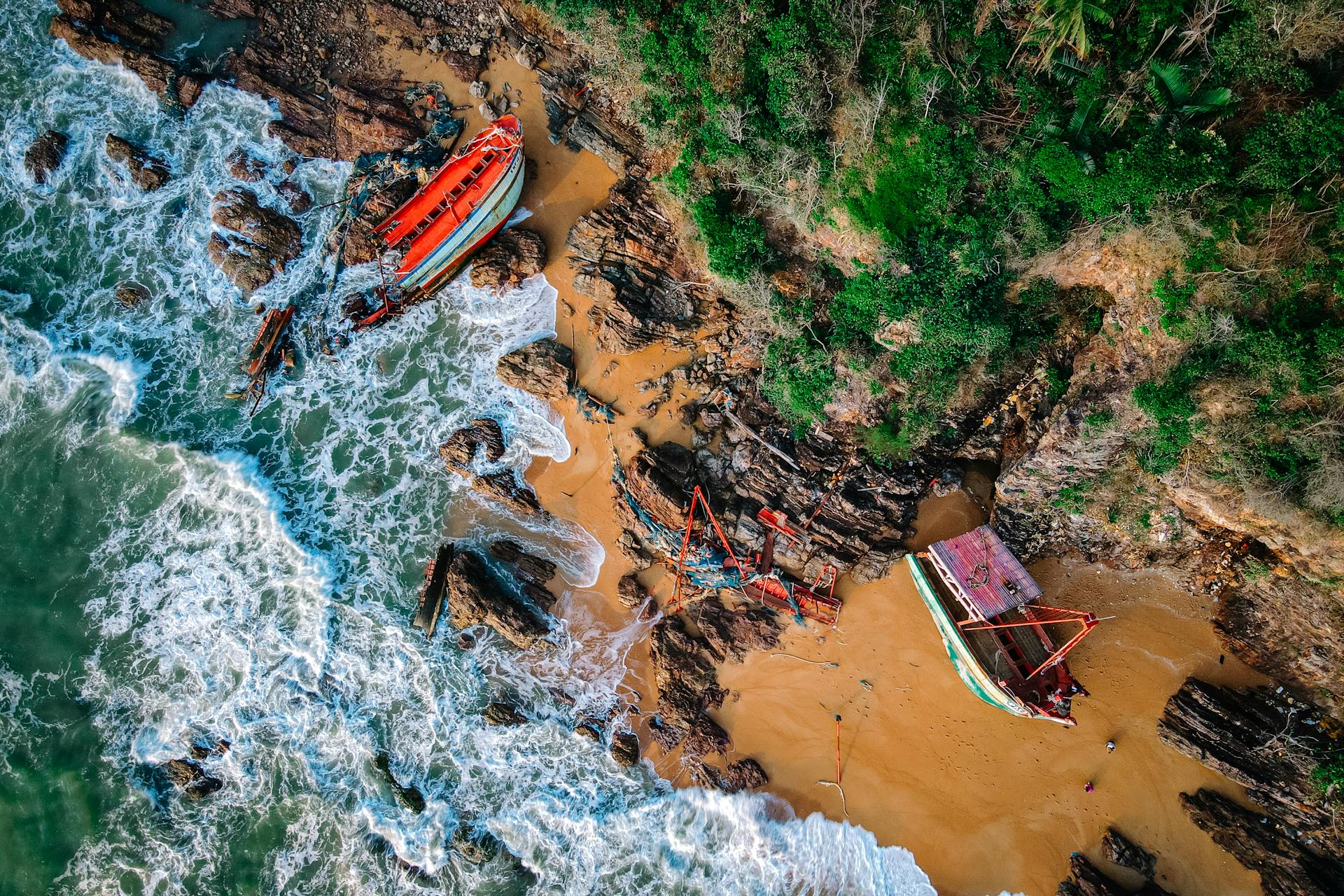 Drone view of shipwrecks on a rocky beach in Kemaman, Malaysia.
