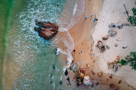 Drone shot of Chukai Beach with rocks, sand, and waves, capturing nature's beauty.