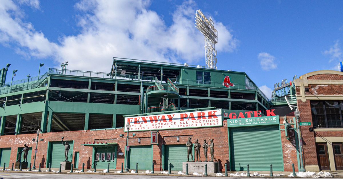 Iconic Fenway Park entrance on a clear day in Boston, showcasing historic architecture and vibrant atmosphere.
