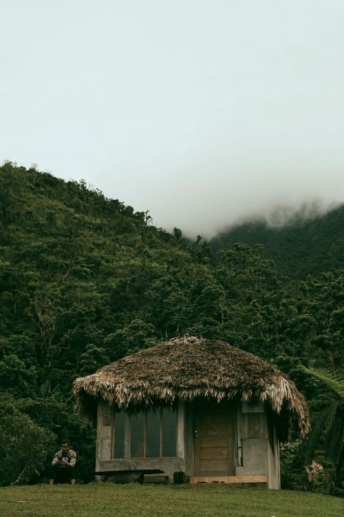 Free A serene rural scene with a nipa hut nestled in a foggy mountain environment, capturing the tranquility of nature. Stock Photo