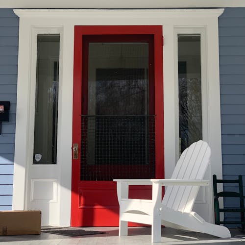 A Low Angle Shot of a Wooden Chair in Front of the Door