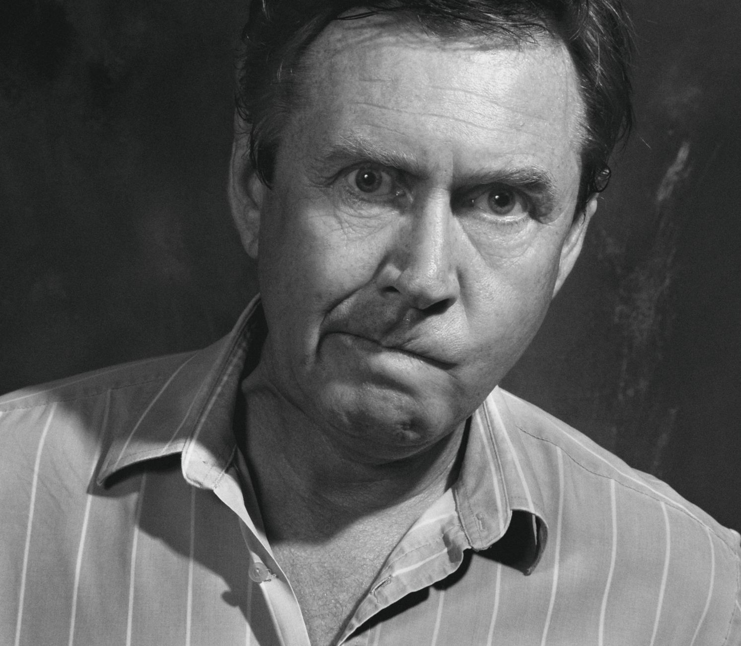 Close-up black and white portrait of a perplexed adult male with quirky expression.