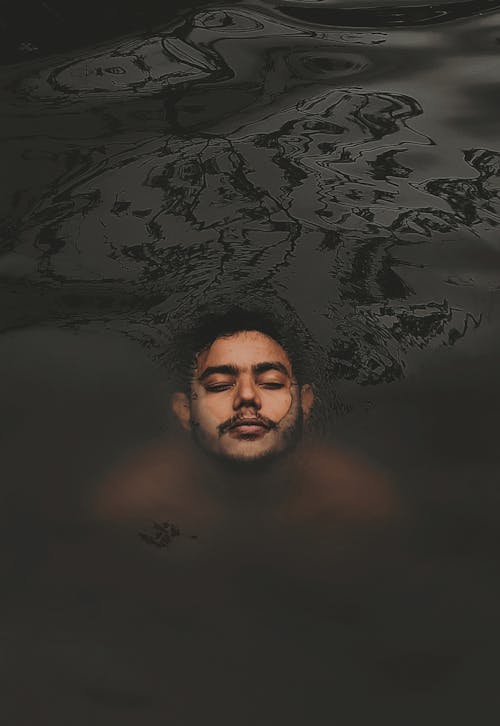 Man with Eyes Closed and Body Submerged in Water