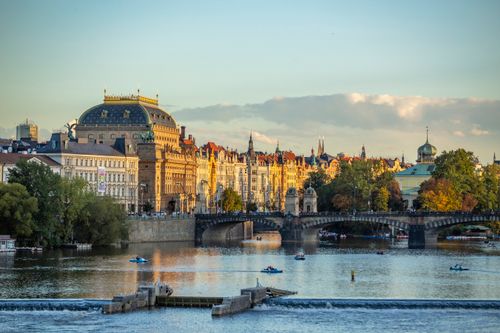 Free Beautiful view of historic buildings by the Vltava River in Prague at sunset. Stock Photo