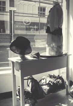 Elegant black and white display of hats, handbags, and mannequins in a chic urban boutique.
