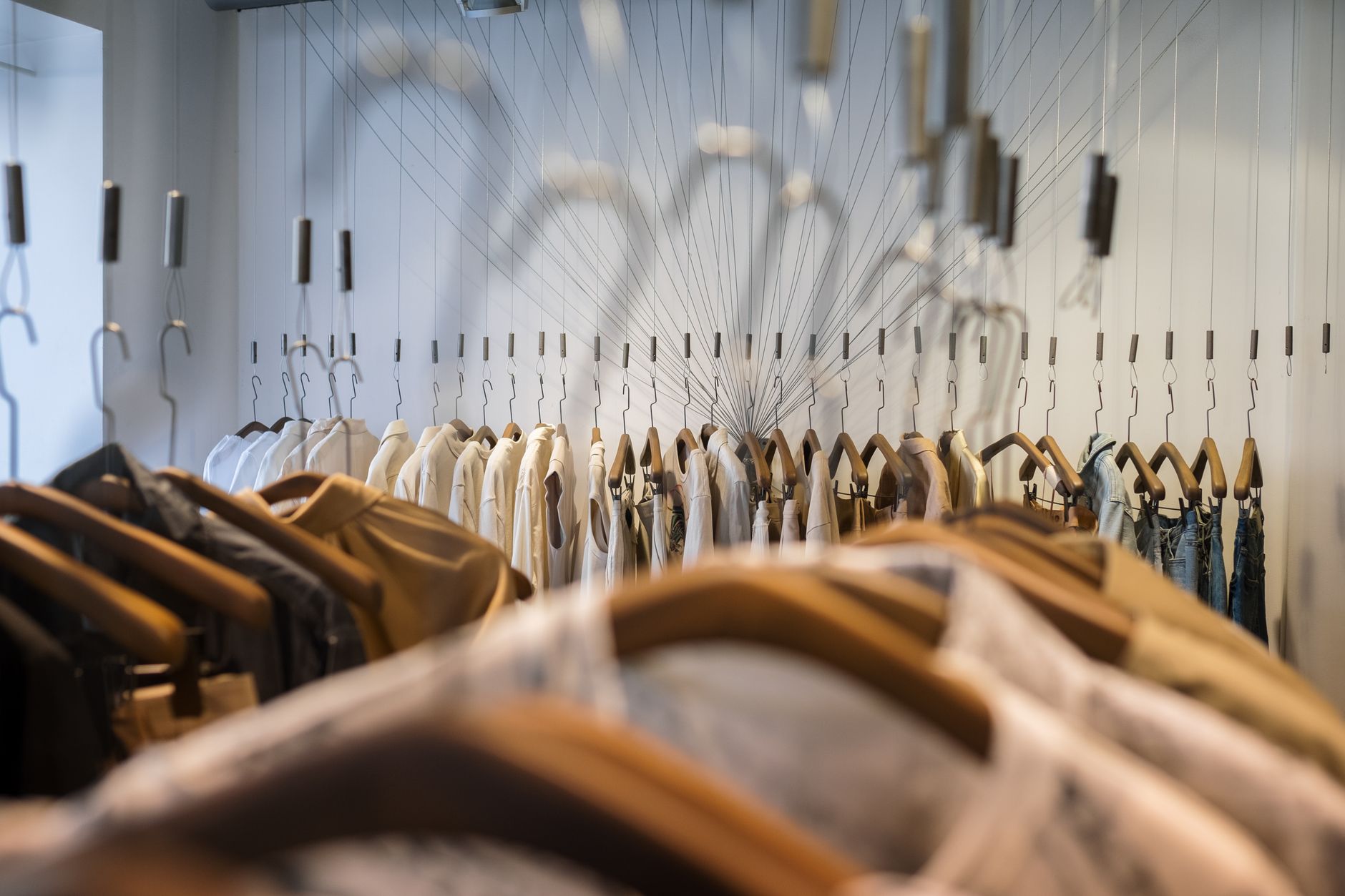 A diverse collection of clothes neatly arranged on hangers in a trendy boutique setting.