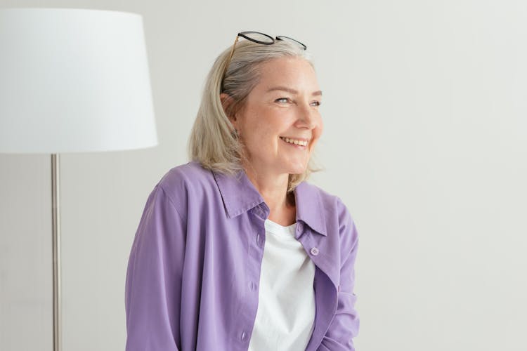 An Elderly Woman In Purple Long Sleeves Smiling