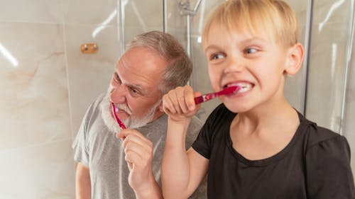 A Man and his Grandson Brushing their Teeth