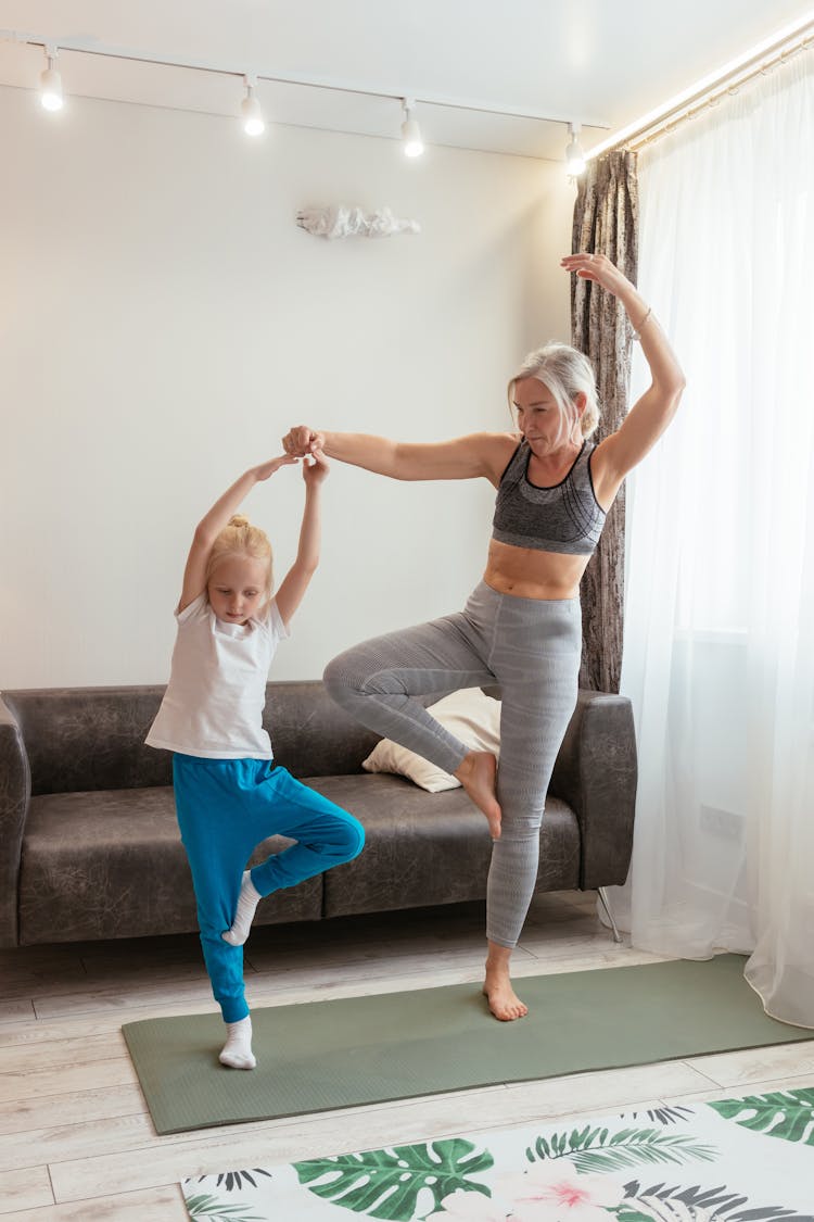 A Grandmother And Granddaughter Exercising At Home