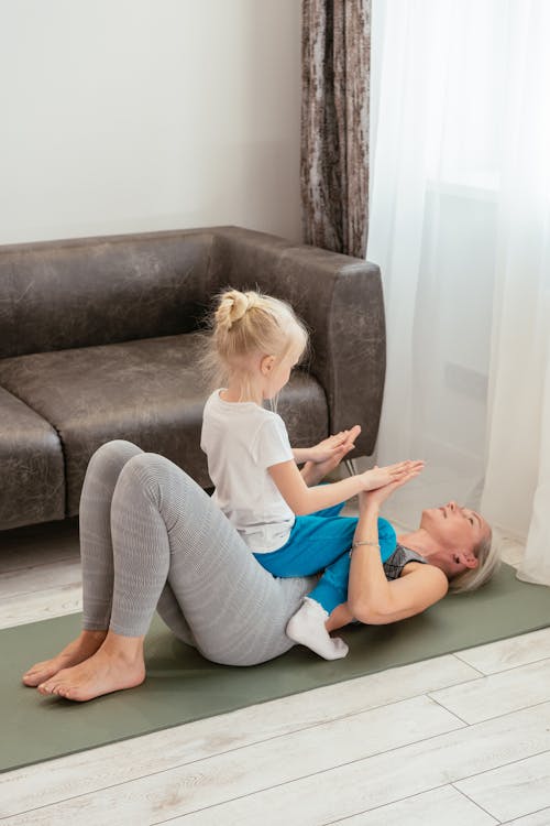 Free A Child Sitting on Her Grandmother's Stomach Stock Photo