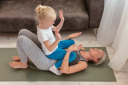 Free A Girl Giving Support to Her Exercising Grandmother Stock Photo