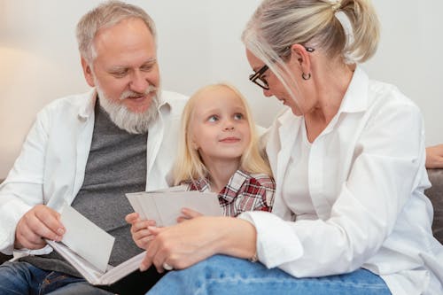 Free Cute Girl Sitting in Between Her Grandparents Stock Photo