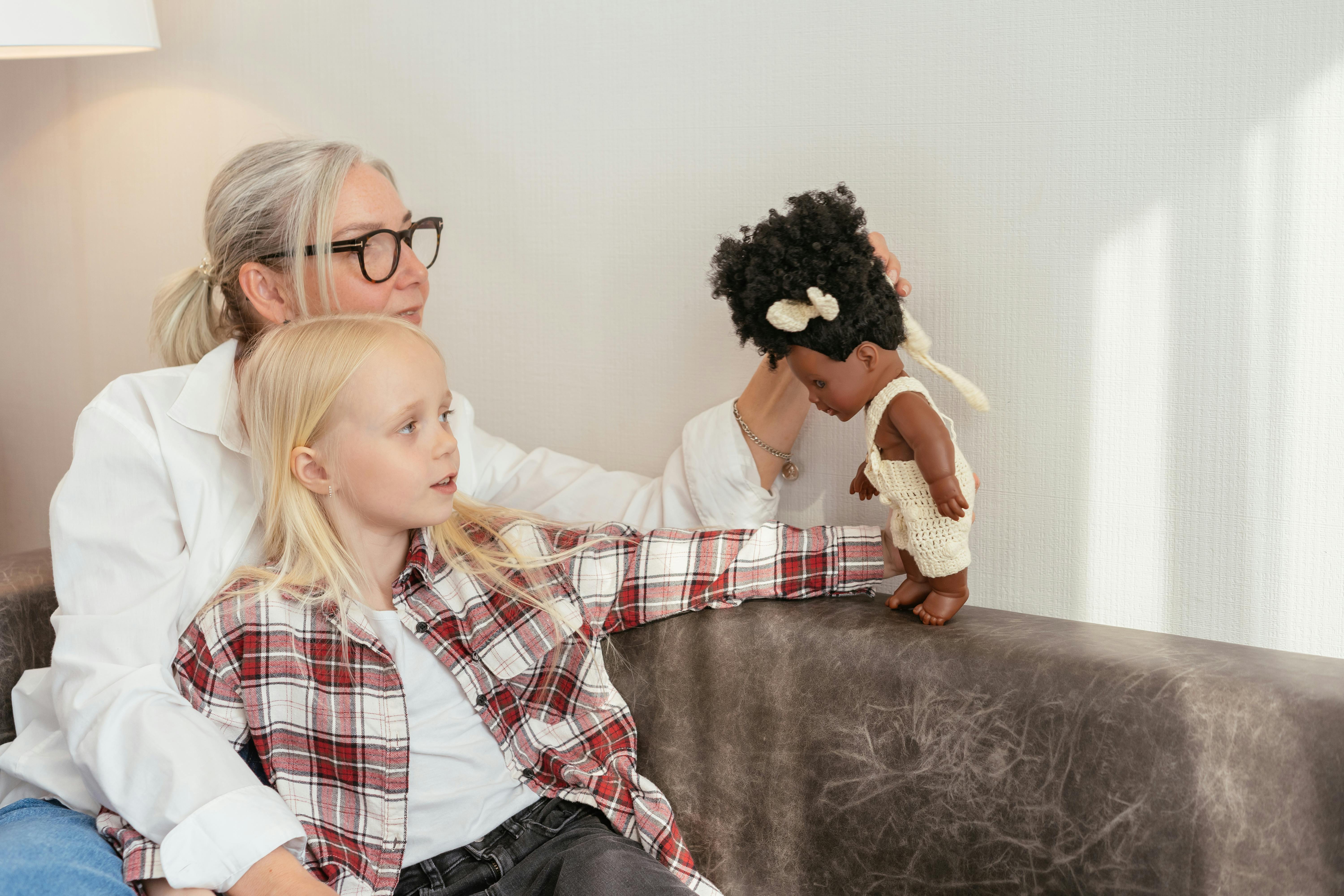 an elderly woman playing with his granddaughter while sitting on the couch