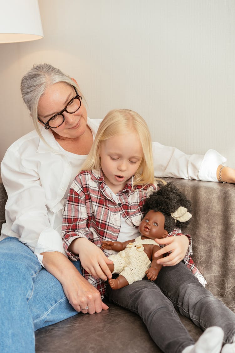 A Woman Playing With Her Granddaughter On A Couch