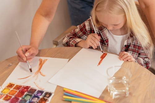 A Girl Painting on the White Piece Paper