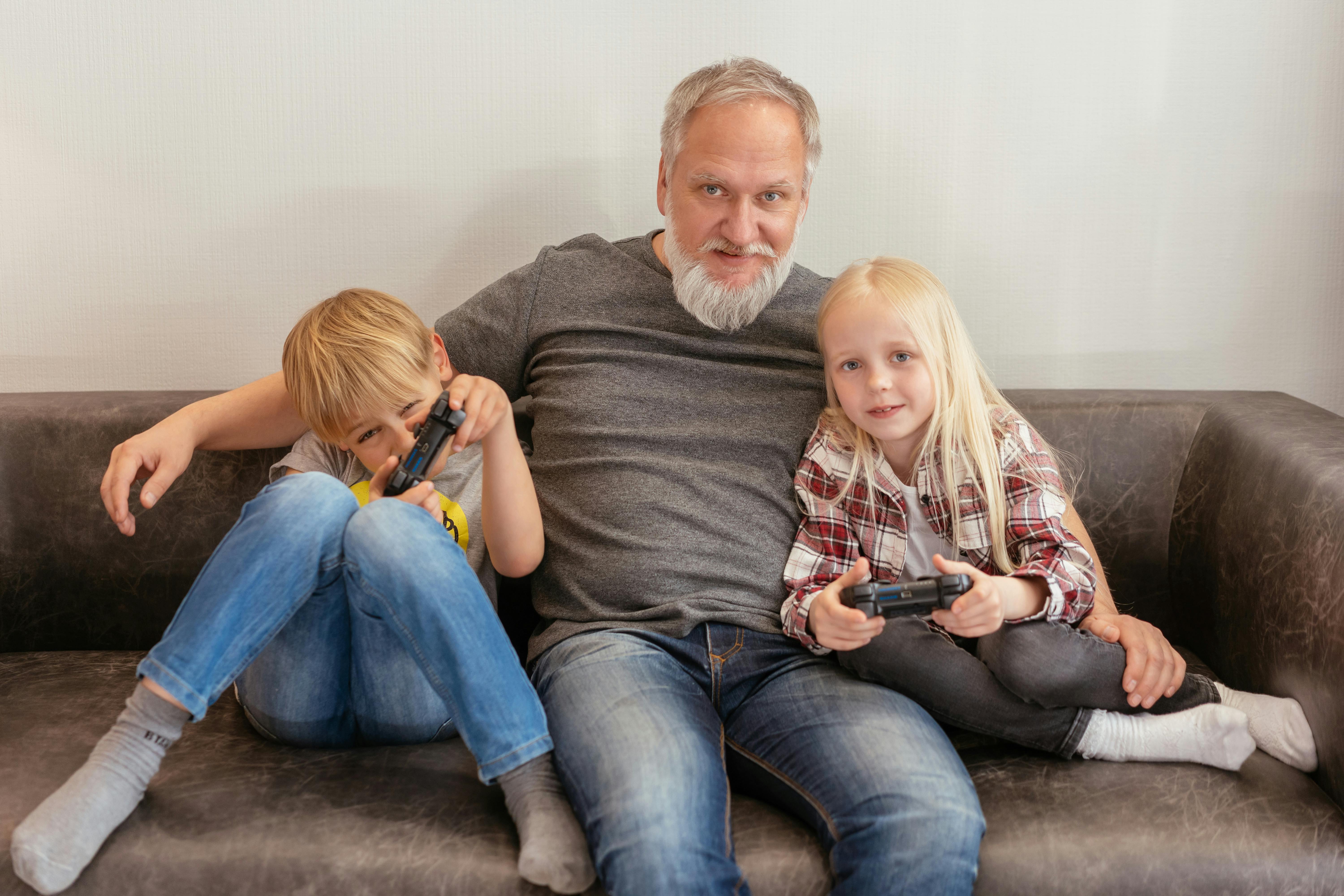 elderly man sitting on sofa with children