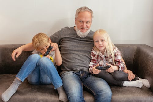 Elderly Man Sitting on Sofa with Children